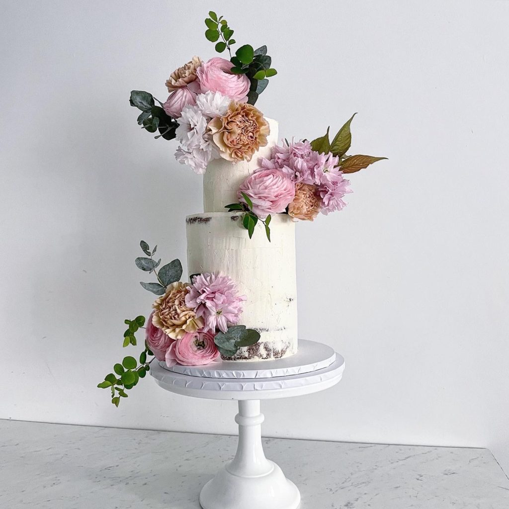 How much does a wedding cake cost? Two-tier wedding cake from £210 plus florals.