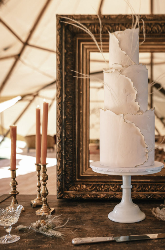 Wedding cake display at Wickerwood Farm. Three tier fondant wedding cake 