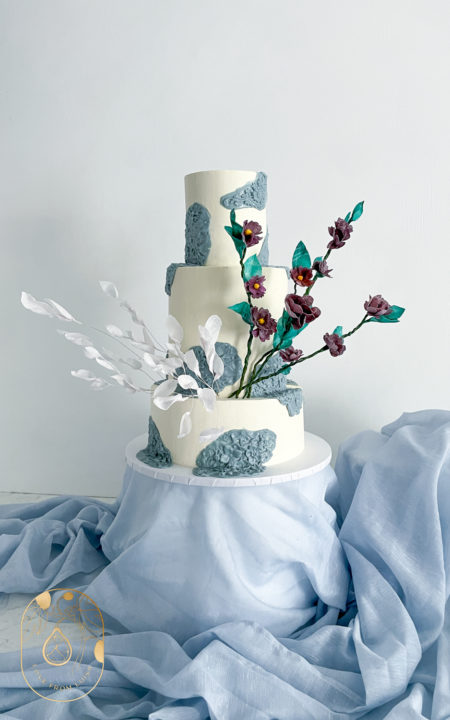 Fondant Wedding Cake with white base and blue fondant details. Wafer Flowers and wafer white leaves