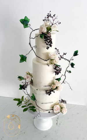 Three tier semi naked wedding cake Woodland theme with ivy and berries. Winter wedding cake