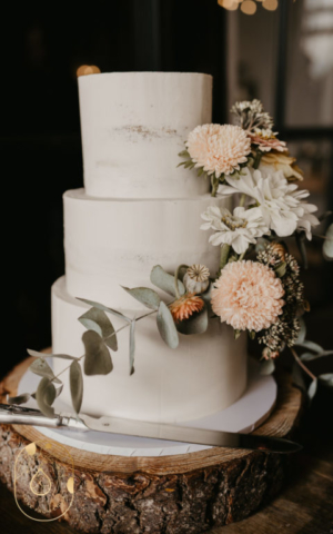 Three Tier Barely Naked Wedding Cake with Flowers. Photo Credit www.sarahmartinsphotography.co.uk