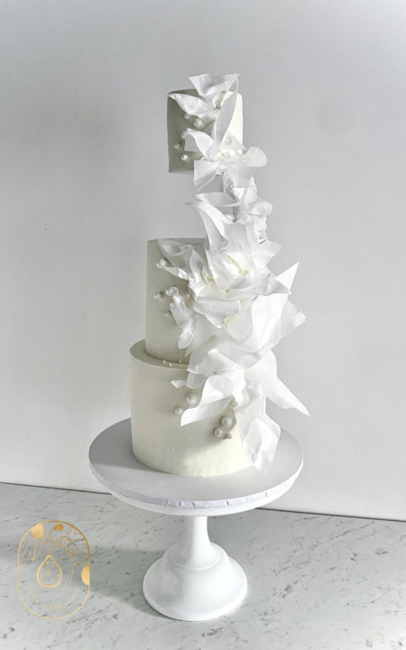Three Tier white wedding cake with floating tier and wafer paper abstract design and white pearls