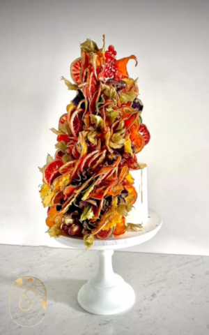 Three tier Vegan Wedding Cake with Autumnal Leaf Fruit Petal Twist and gold details