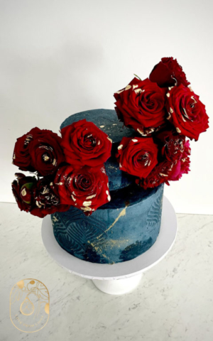 Two-tier vegan wedding cake dark blue and red roses