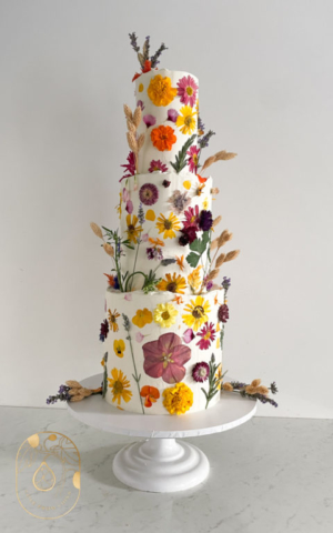 Three-tier vegan pressed flower wedding cake in natural botanical style