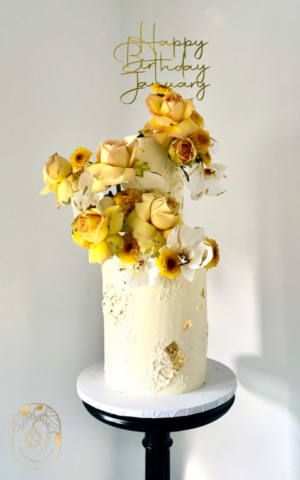 Tall two-tier birthday cake with flowers in neutral tones