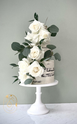 Three Tier semi-Naked vegan wedding cake with white roses and eucalyptus