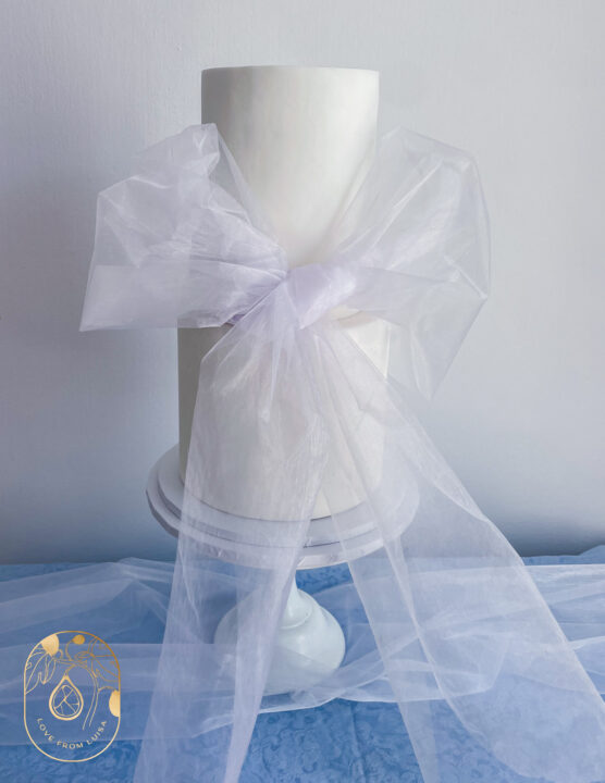 Two tier wedding cake styled with modern oversized tulle material