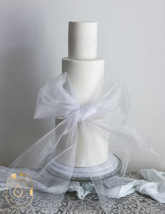 Three tier wedding cake with clear oversized bow