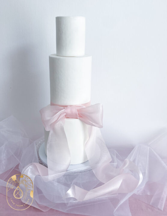 three tiers of delicious cake in white and pastel pink