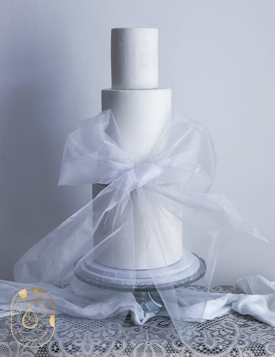 White wedding cake with oversized tulle bow