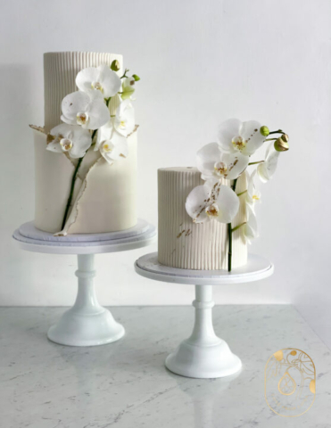 Two tier and single tier white wedding cake. Simple white wedding cake with orchids