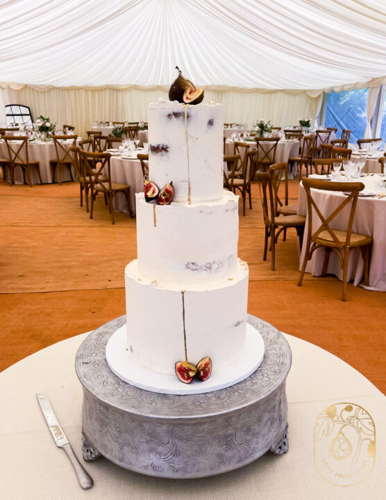 Three tier rustic wedding cake with gold drip and figs