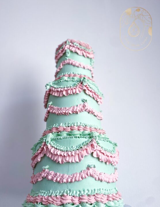 pink and green three tier ornately piped wedding cake image taken from below