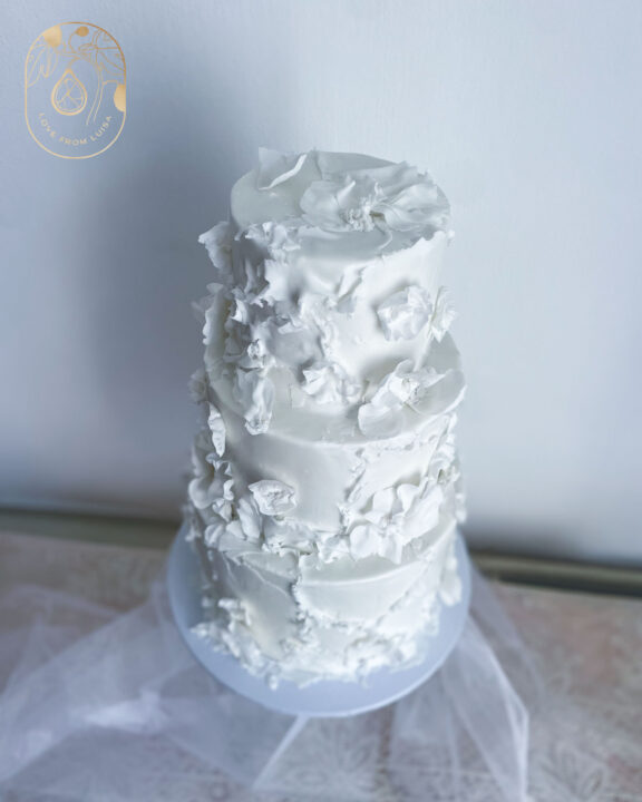 Three tier white Fondant wedding cake with delicate flowers to match the bride's dress